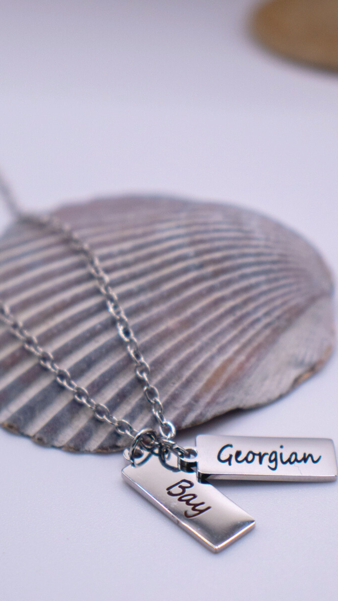 Two silver rectangular pendants on a silver chain with 'Georgian Bay' engraved on them.